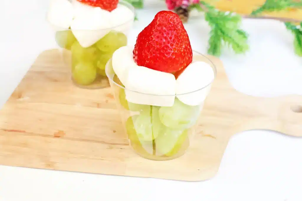 Grinch Fruit Cup - Cultivating Brilliant Minds a grinch fruit cup made with green grapes, mini marshmallows, and strawberries