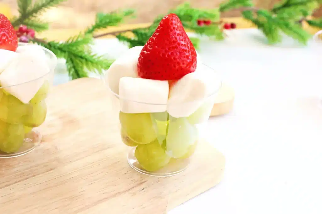 Grinch Fruit Cup - Cultivating Brilliant Minds a grinch fruit cup made with green grapes, mini marshmallows, and strawberries