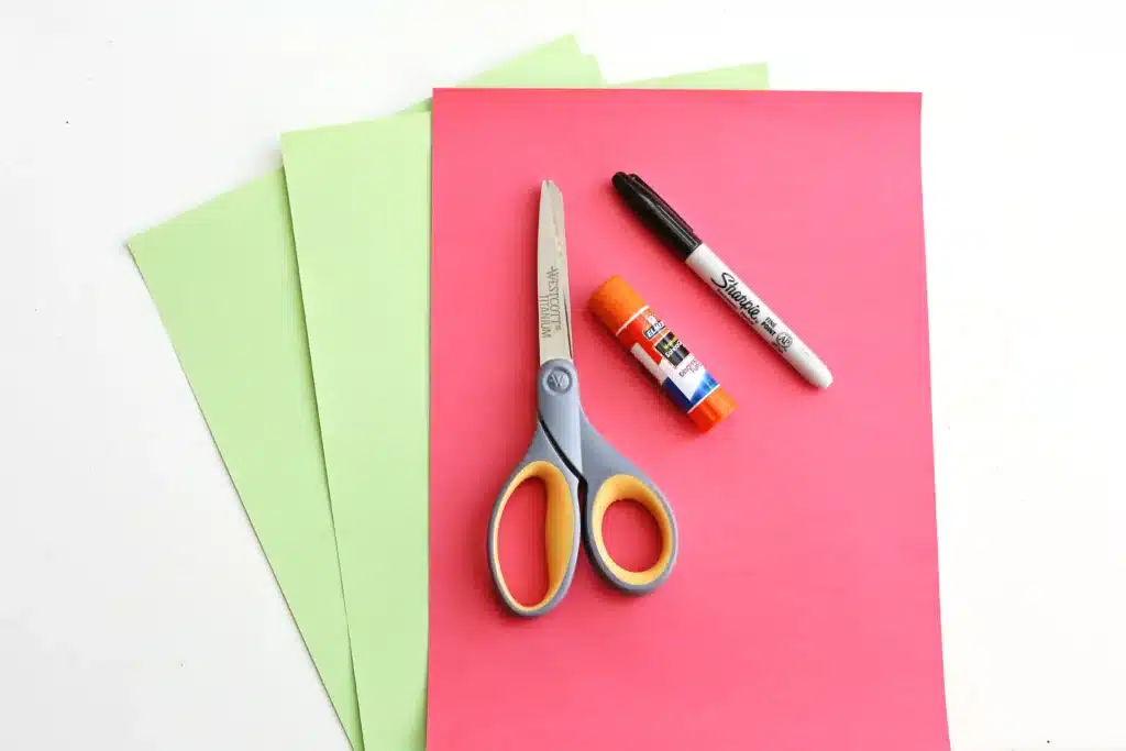 Grinch Paper Chain Countdown - Cultivating Brilliant Minds red and green construction paper, scissors, glue, and a black marker