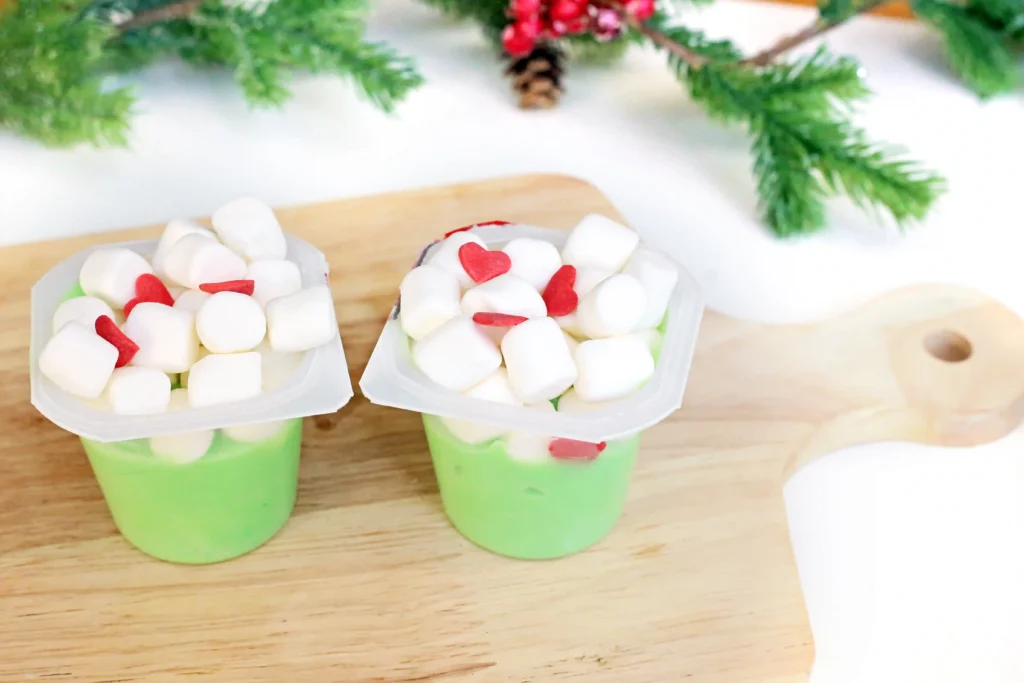 Grinch Pudding - Cultivating Brilliant Minds a vanilla pudding cup dyed green with marshmallows and candy hearts