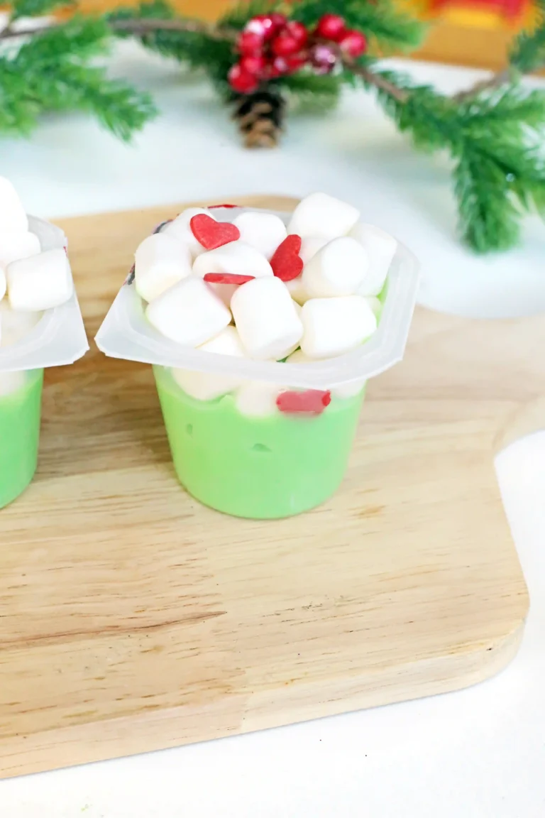 a vanilla pudding cup dyed green with marshmallows and candy hearts