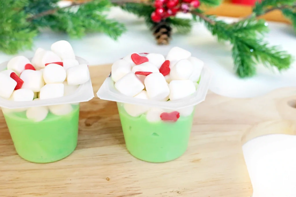Grinch Pudding - Cultivating Brilliant Minds a vanilla pudding cup dyed green with marshmallows and candy hearts