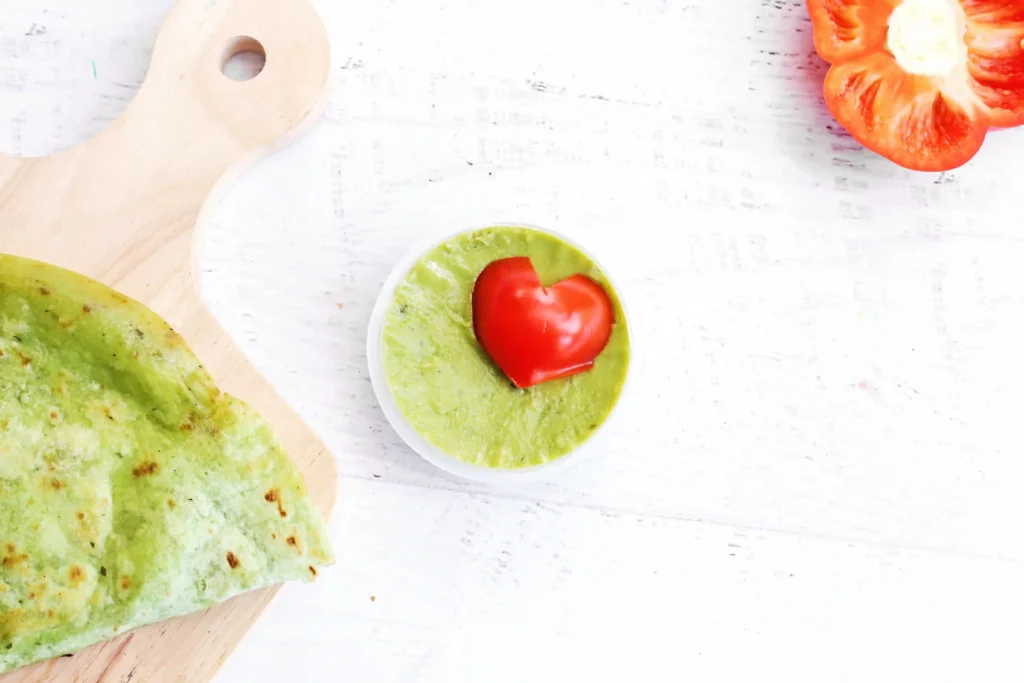 Grinch Quesadillas - Cultivating Brilliant Minds guacamole dip with a red heart inside