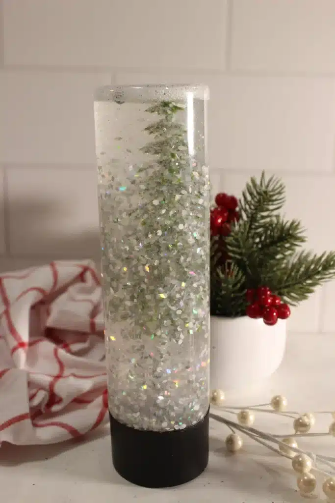 Snow Globe Sensory Bottle - Cultivating Brilliant Minds a snow globe sensory bottle with a christmas tree inside