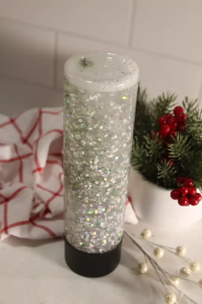 Snow Globe Sensory Bottle - Cultivating Brilliant Minds a snow globe sensory bottle with a christmas tree inside
