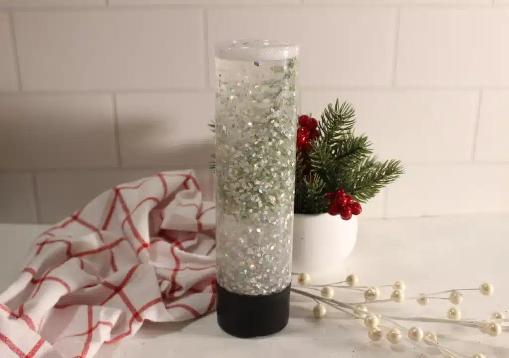 Snow Globe Sensory Bottle - Cultivating Brilliant Minds a snow globe sensory bottle with a christmas tree inside