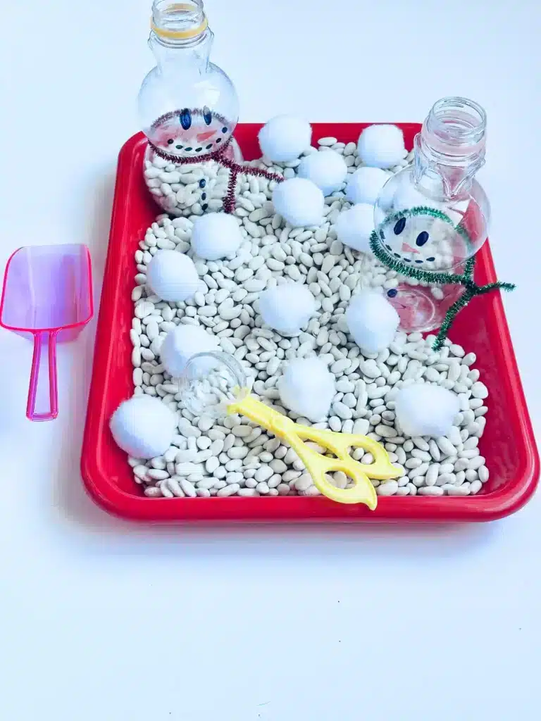 a snowman sensory bin using beans and cotton balls
