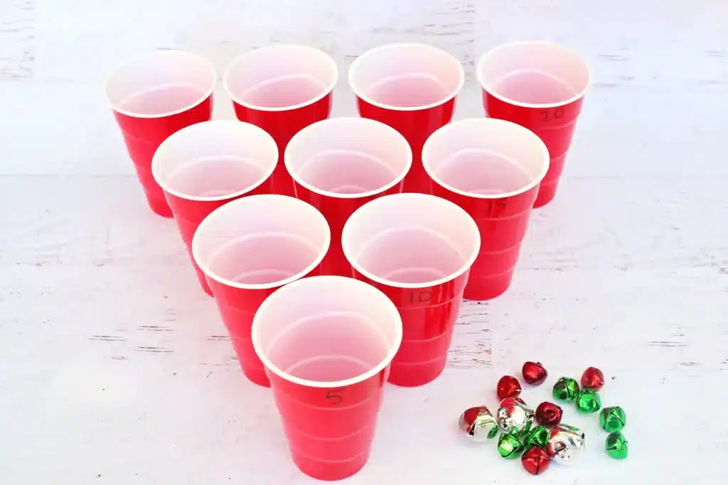 Jingle Bell Toss Reindeer Game - Cultivating Brilliant Minds red cups with numbers written on them and multicolored jingle bells