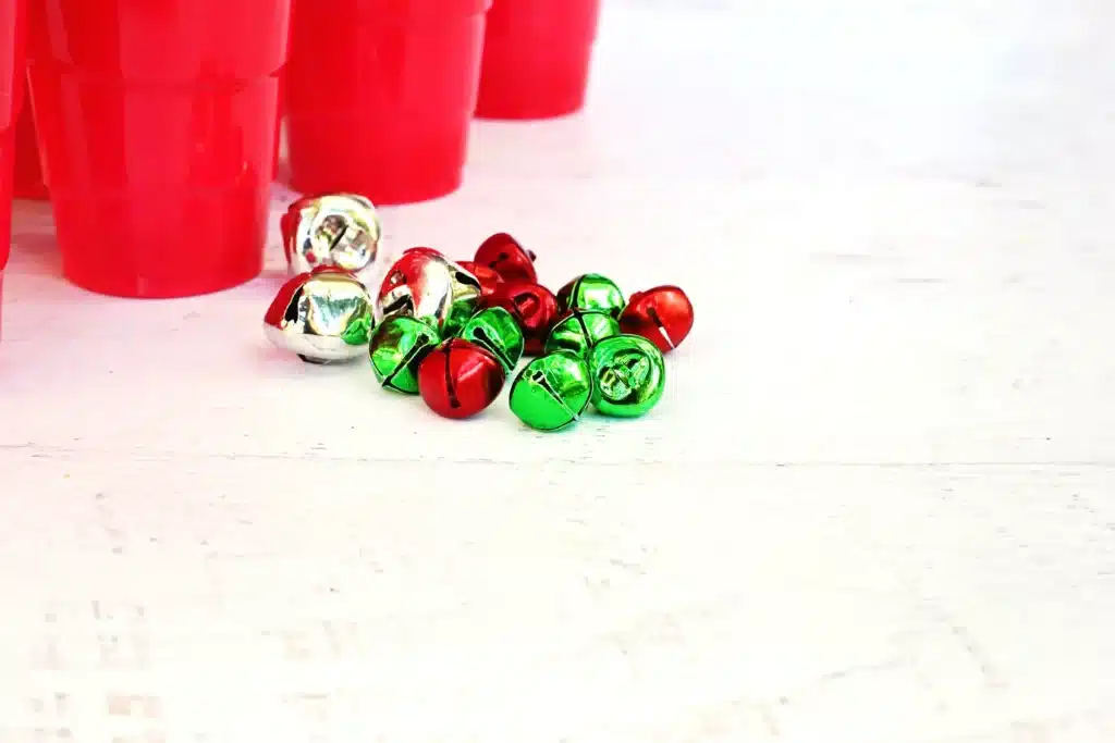 Jingle Bell Toss Reindeer Game - Cultivating Brilliant Minds red cups with numbers written on them and multicolored jingle bells