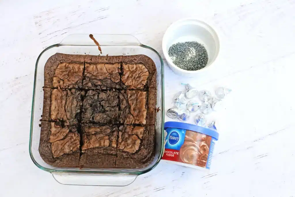 Midnight Kiss Brownies - Cultivating Brilliant Minds brownies, chocolate icing, hershey kisses, and gold sprinkles