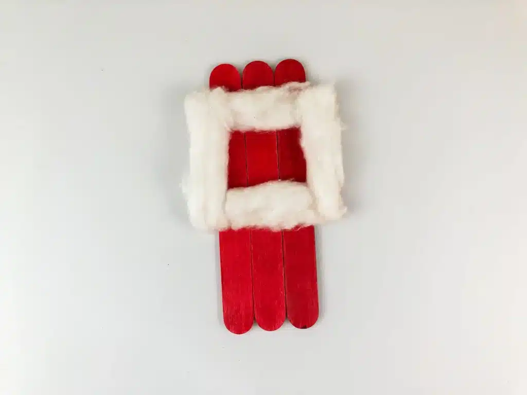 Santa Popsicle Stick Ornament Craft - Cultivating Brilliant Minds cotton glued on popsicle sticks painted red