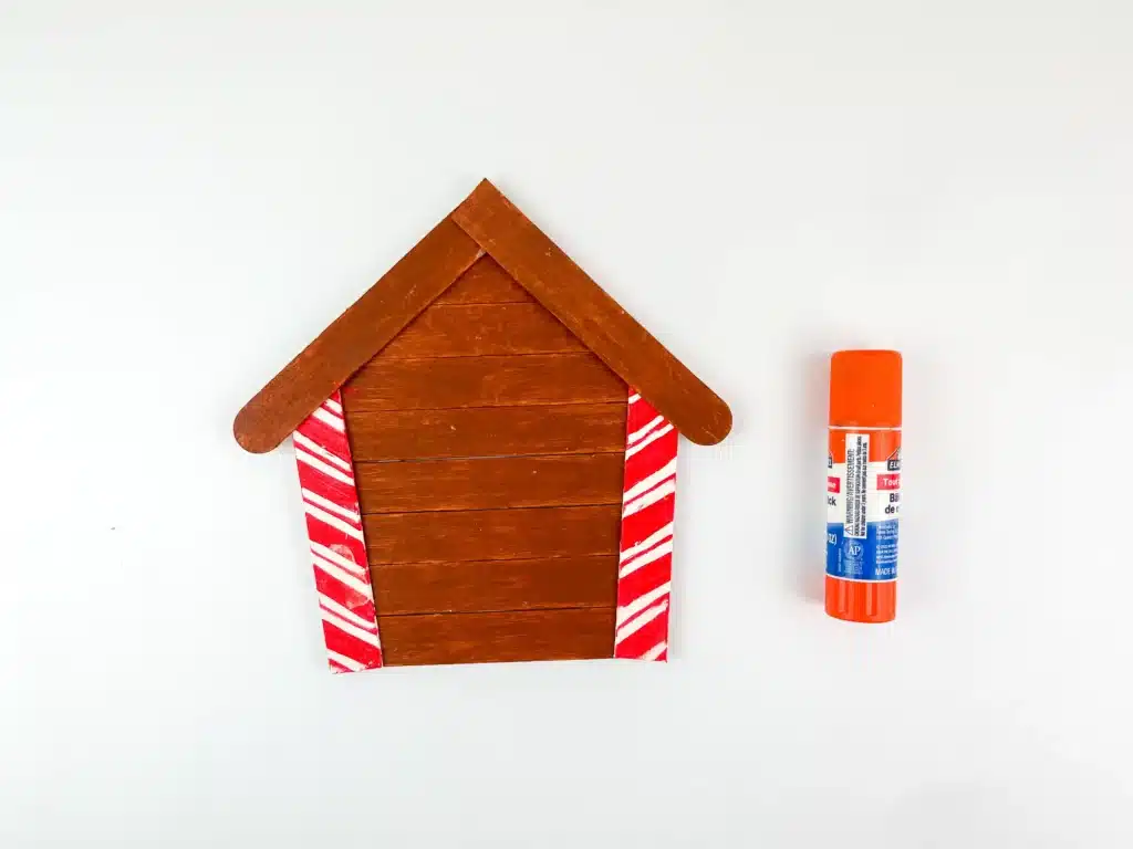 Gingerbread House Craft - Cultivating Brilliant Minds a gingerbread house made of popsicle sticks painted brown