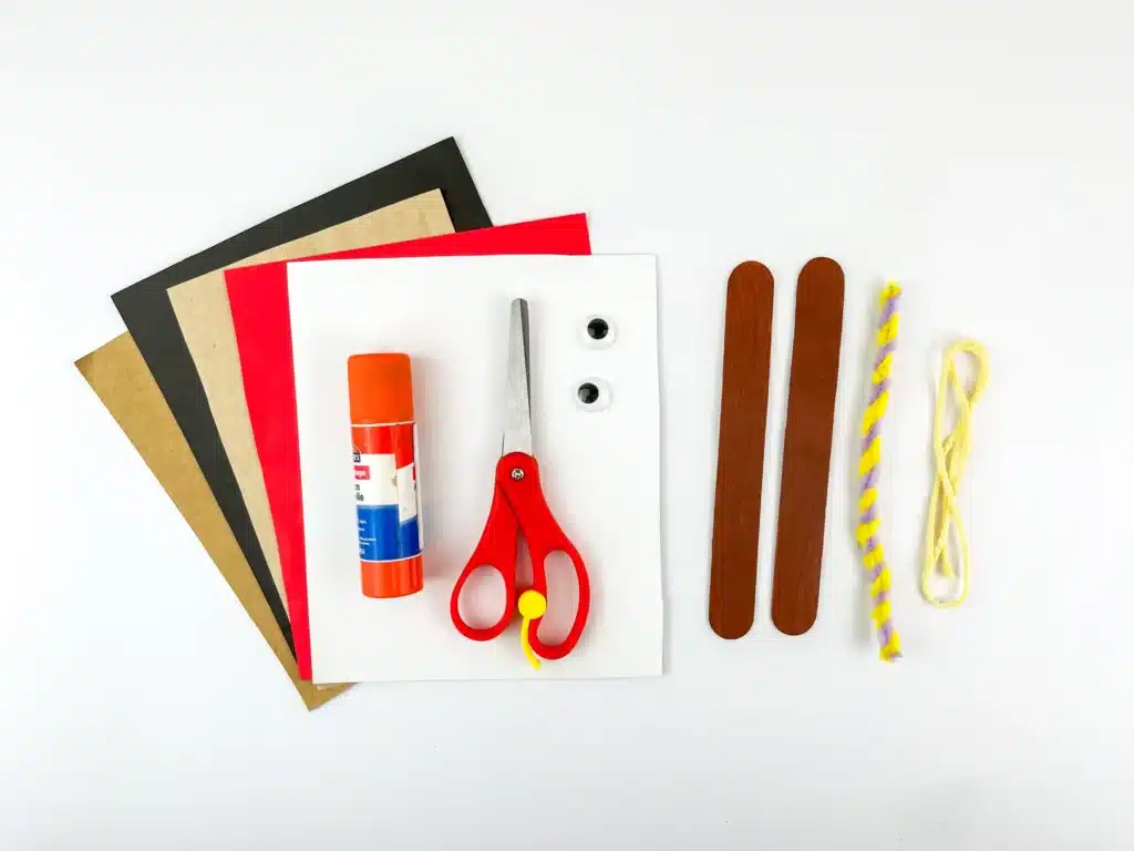 Reindeer Popsicle Stick Ornament Craft - Cultivating Brilliant Minds colored construction paper, scissors, glue, googly eyes, popsicle sticks painted brown, yarn, and pipe cleaners