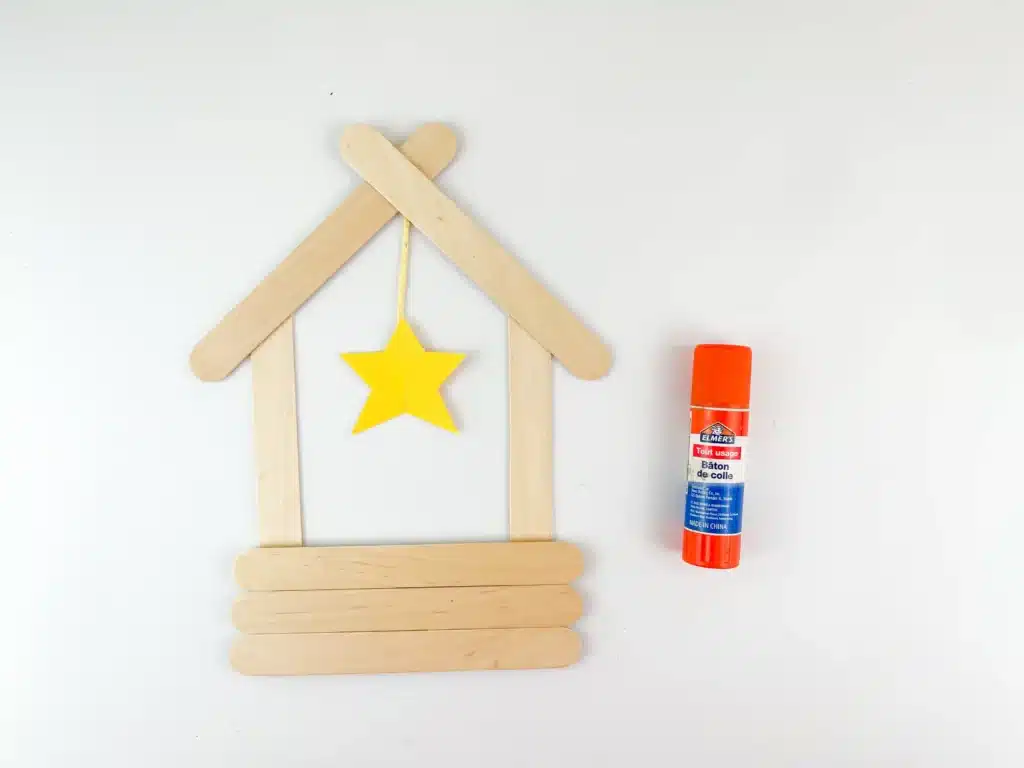 Manger Popsicle Stick Craft - Cultivating Brilliant Minds popsicle sticks glued together to look like a manger with a yellow star made out of construction paper