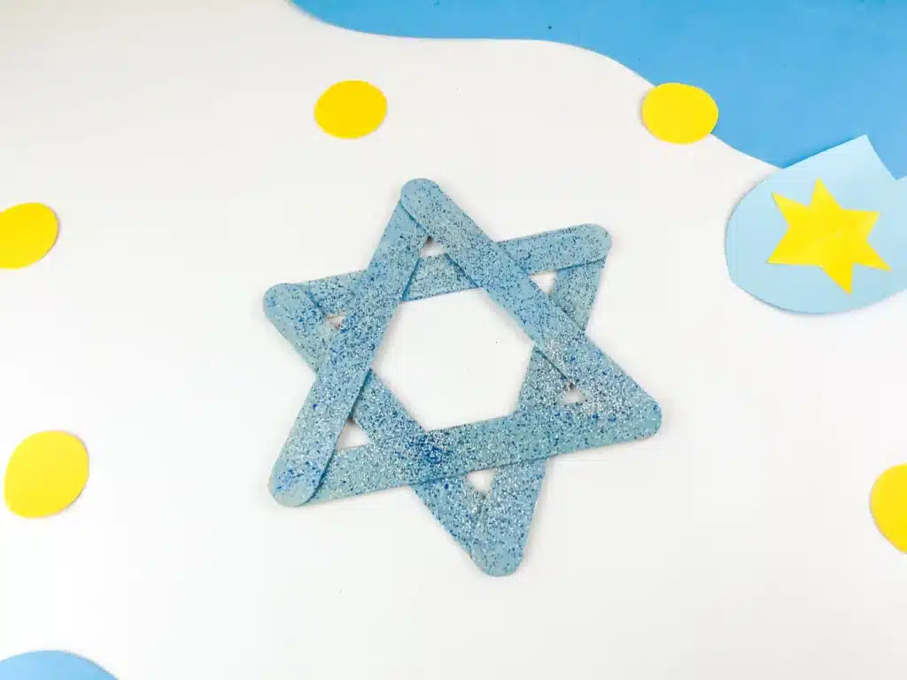 Star of David Craft - Cultivating Brilliant Minds blue popsicle sticks with blue and silver glitter glued together to look like the star of david