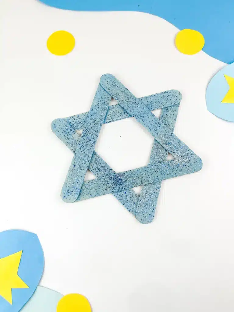 Star of David Craft - Cultivating Brilliant Minds blue popsicle sticks with blue and silver glitter glued together to look like the star of david
