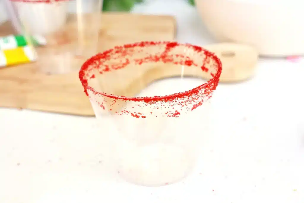 Grinch Shake - Cultivating Brilliant Minds a plastic cup with red sanding sugar around the rim