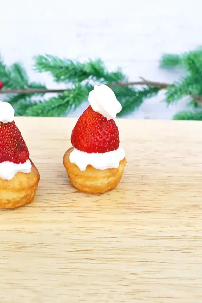 Santa Hat Muffins - Cultivating Brilliant Minds muffins with whipped cream and a strawberry to look like a santa hat