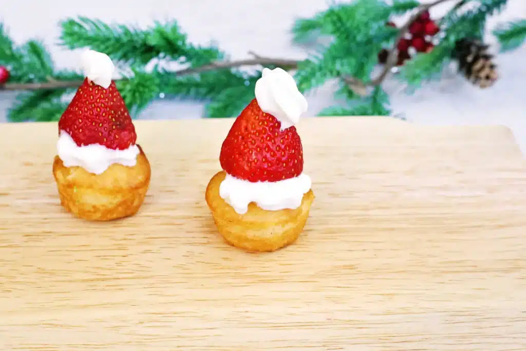 Santa Hat Muffins - Cultivating Brilliant Minds muffins with whipped cream and a strawberry to look like a santa hat