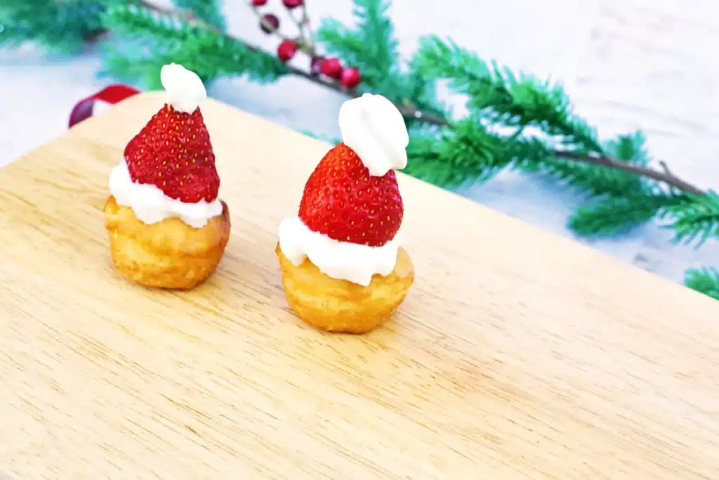 Santa Hat Muffins - Cultivating Brilliant Minds muffins with whipped cream and a strawberry to look like a santa hat