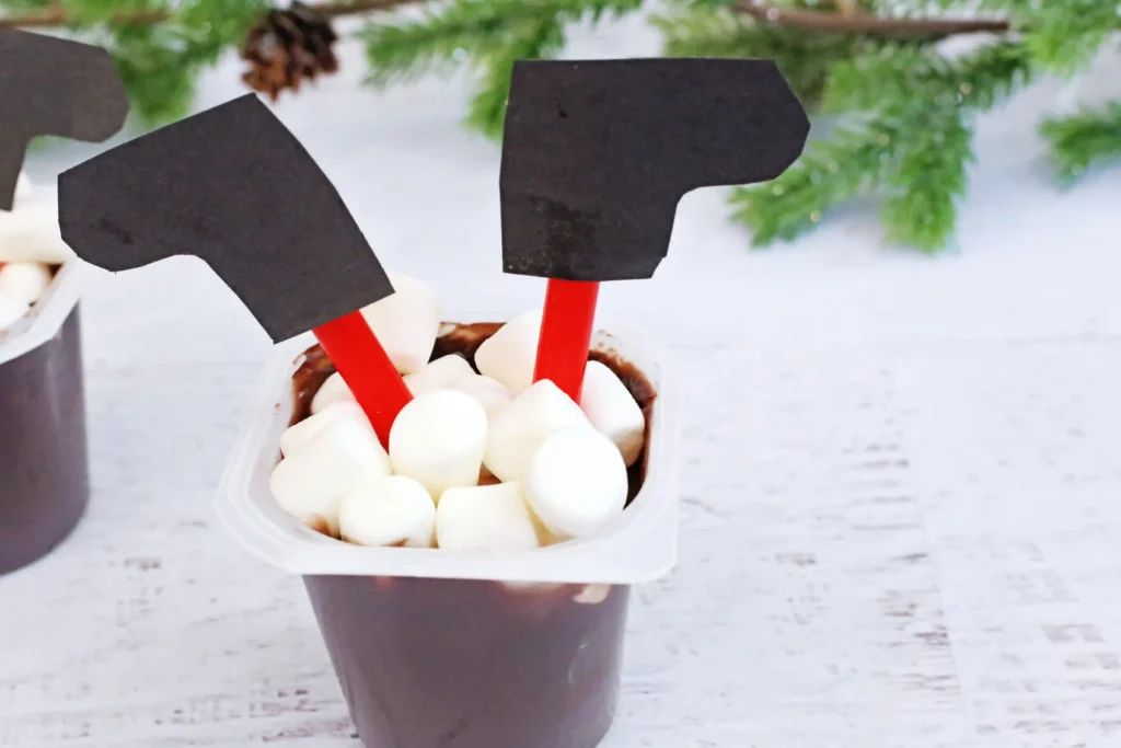 Santa in the Chimney Pudding Snack - Cultivating Brilliant Minds A pudding cup decorated to look like santa is in the chimney with his legs sticking out