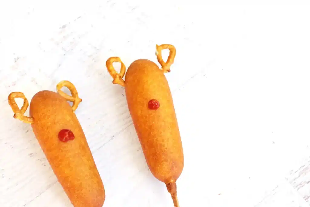 Rudolph Corn Dogs - Cultivating Brilliant Minds corn dogs with pretzel ears and a dab of ketchup for a nose