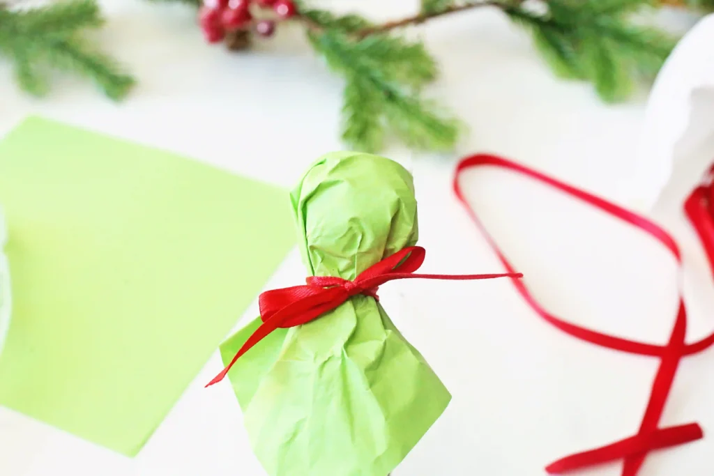 Grinch Lollipops - Cultivating Brilliant Minds a lollipop wrapped with green tissue paper and tied with a ribbon