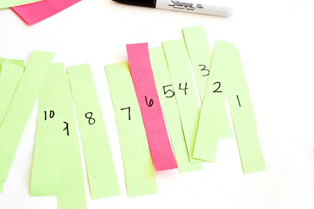 Grinch Paper Chain Countdown - Cultivating Brilliant Minds numbers written in black marker on the strips of construction paper