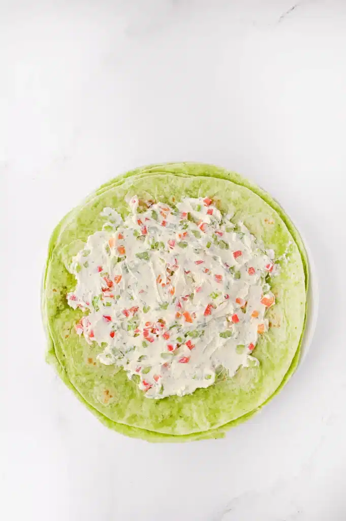 Christmas Pinwheels - Cultivating Brilliant Minds cream cheese and veggie mixture spread on a spinach wrap