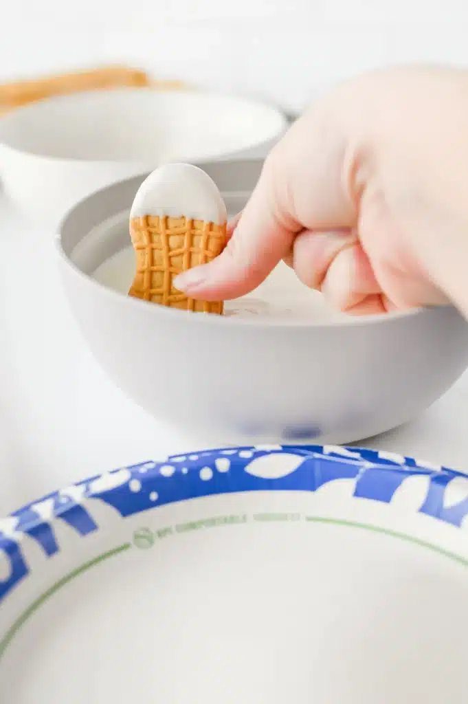 Santa Nutter Butters - Cultivating Brilliant Minds dipping the other side of the nutter butter in melted white chocolate