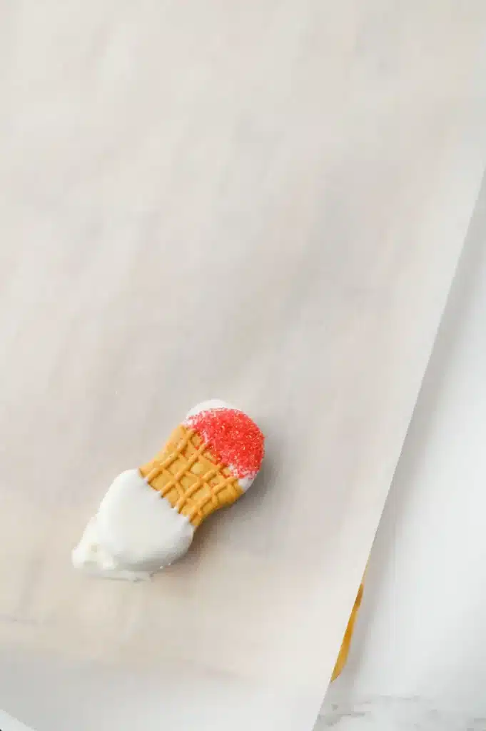 Santa Nutter Butters - Cultivating Brilliant Minds nutter butter with white on the ends and one end has red sanding sugar on top of the melted chocolate