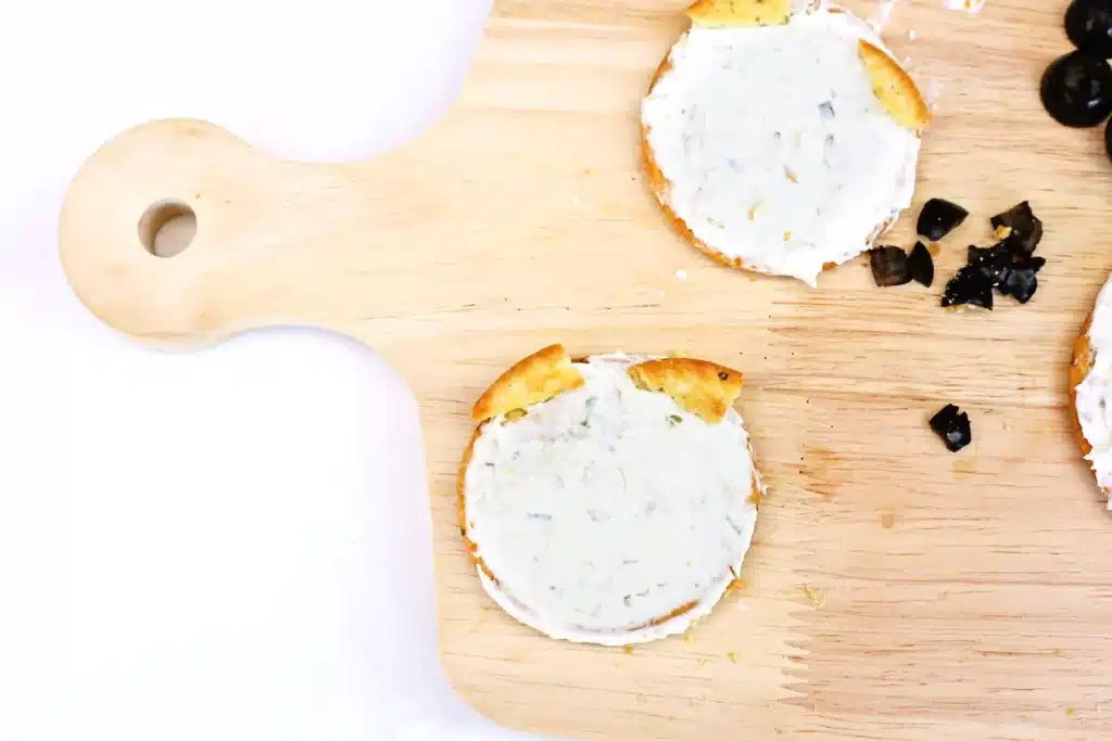 Savory Polar Bear Snacks - Cultivating Brilliant Minds a round cracker with cream cheese and pieces of cracker on top to look like ears