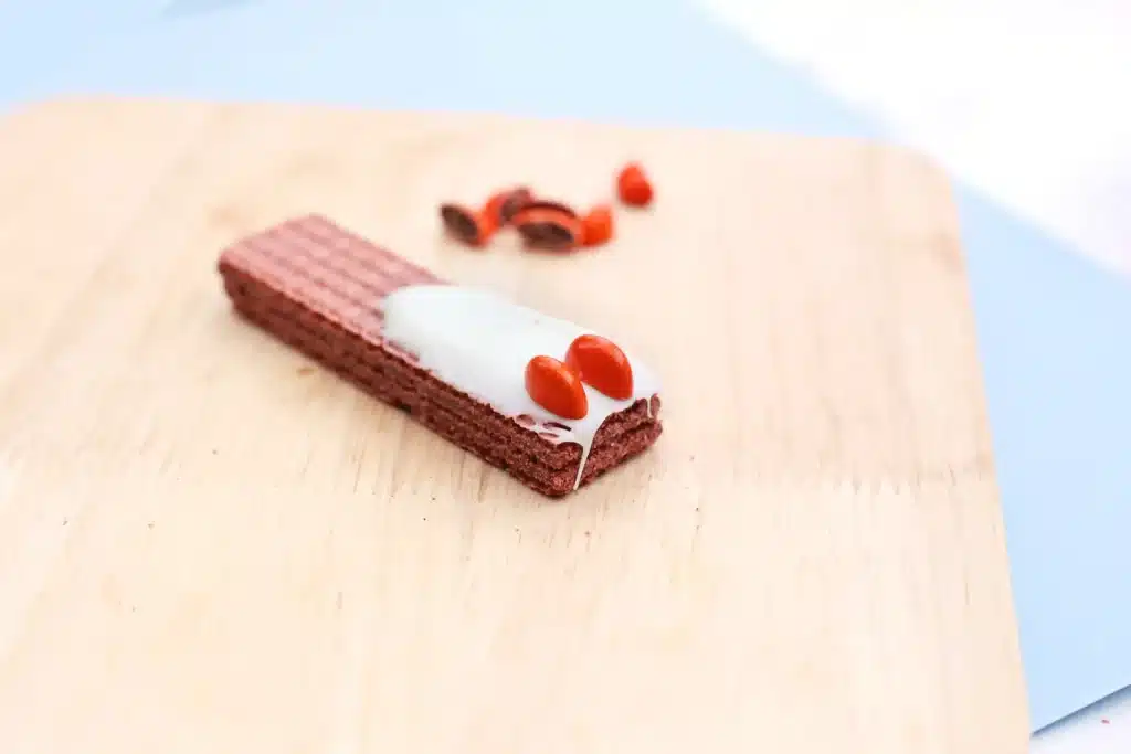 Penguin Wafers - Cultivating Brilliant Minds chocolate wafers with melted chocolate smeared on the bottom and m&ms cut in half to look like feet