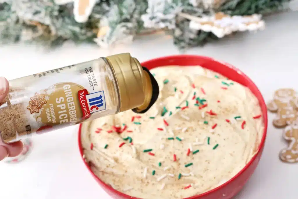Gingerbread Dip - Cultivating Brilliant Minds adding christmas sprinkles and cinnamon to the dip