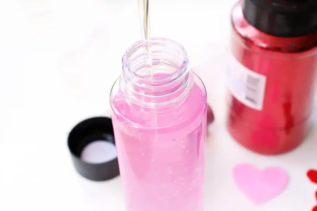 Love Potion Valentine Sensory Bottle - Cultivating Brilliant Minds adding glue to the bottle