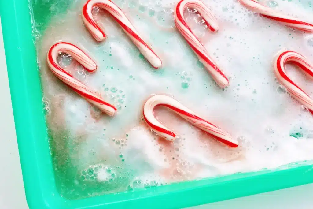 Fizzy Candy Cane Experiment - Cultivating Brilliant Minds candy canes fizzing in baking soda and vinegar