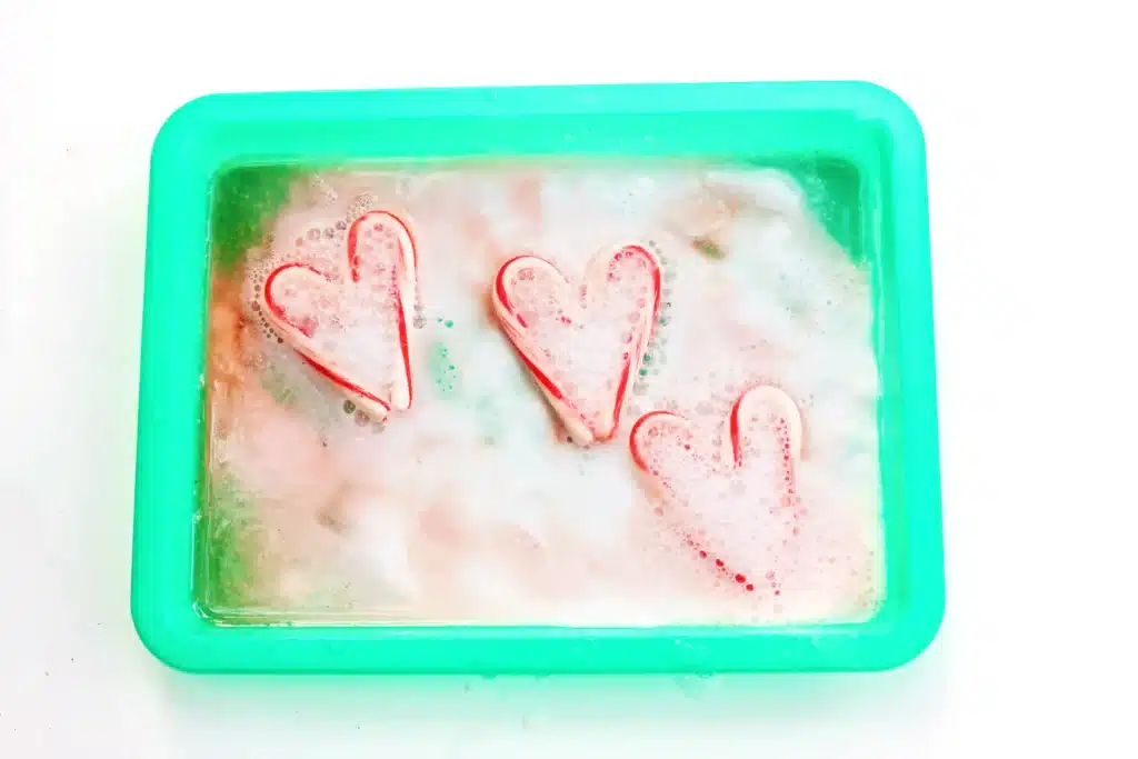 Fizzy Candy Cane Experiment - Cultivating Brilliant Minds candy canes fizzing in baking soda and vinegar