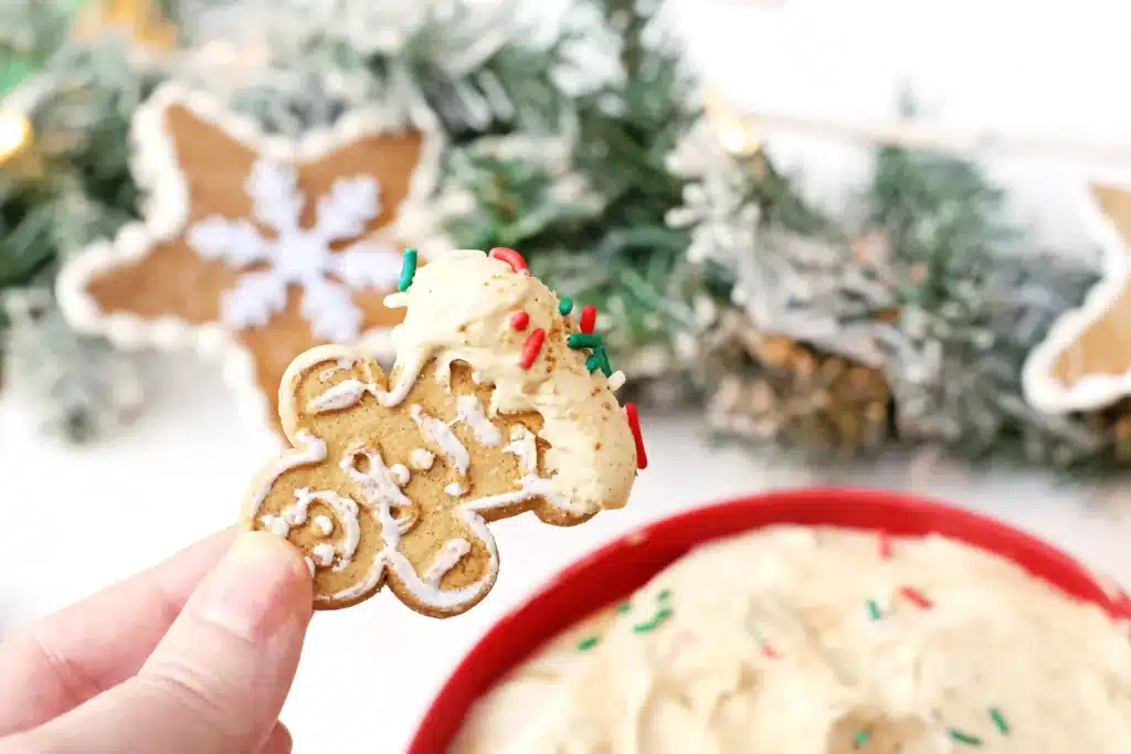 Gingerbread Dip - Cultivating Brilliant Minds a person holding a gingerbread cookie dipped in the gingerbread dip