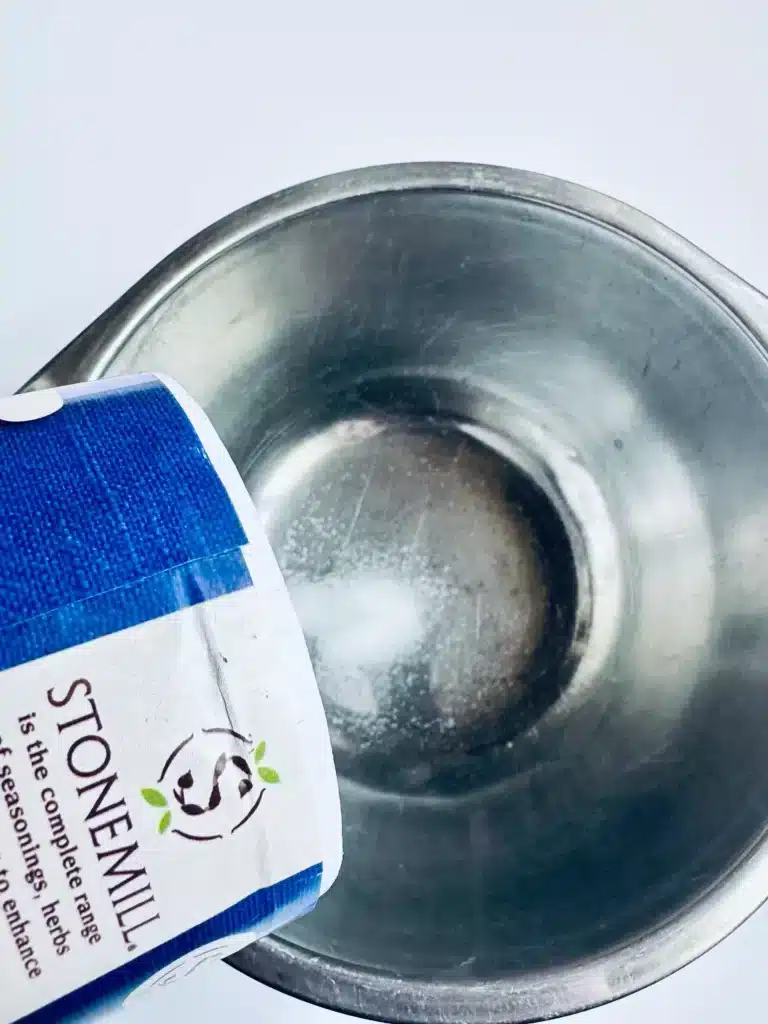 New Year's Eve Sensory Bin - Cultivating Brilliant Minds dumping salt into a bowl