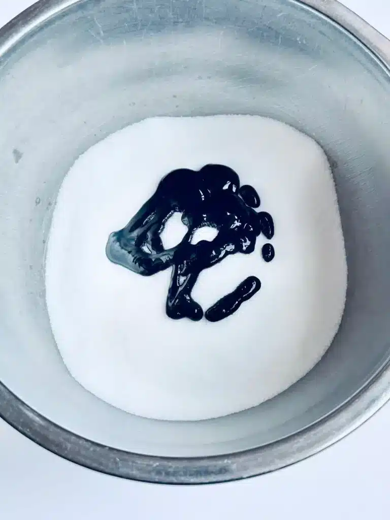 New Year's Eve Sensory Bin - Cultivating Brilliant Minds add black paint to the salt