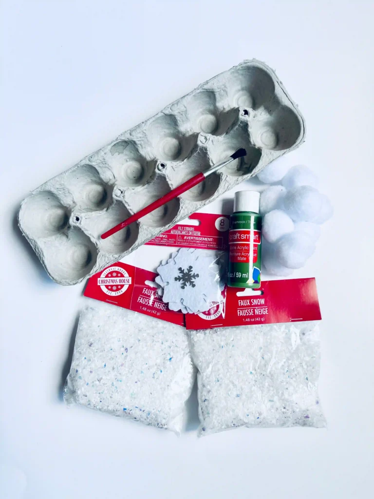 Egg Carton Sensory Bin - Cultivating Brilliant Minds egg carton, green paint, paint brush, and fake snow
