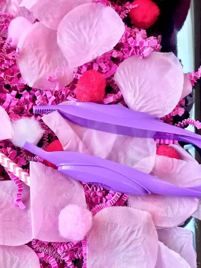 Valentine's Day Sensory Bin - Cultivating Brilliant Minds a valentine's day sensory bin with crinkle paper. rose petals, pom poms, and straws