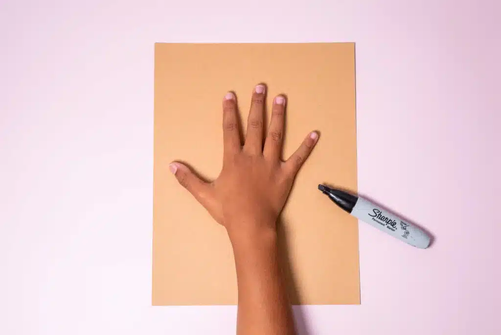 Valentine's Day Heart Tree Craft - Cultivating Brilliant Minds a child's hand on construction paper