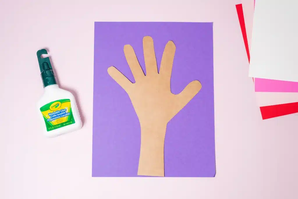 Valentine's Day Heart Tree Craft - Cultivating Brilliant Minds a hand and arm cut out of construction paper and glued onto purple paper