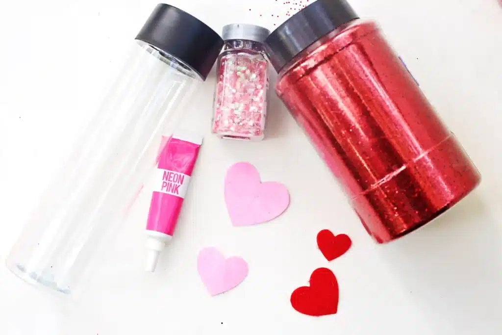 Love Potion Valentine Sensory Bottle - Cultivating Brilliant Minds red and pink glitter, plastic bottle, pink food coloring, and felt hearts