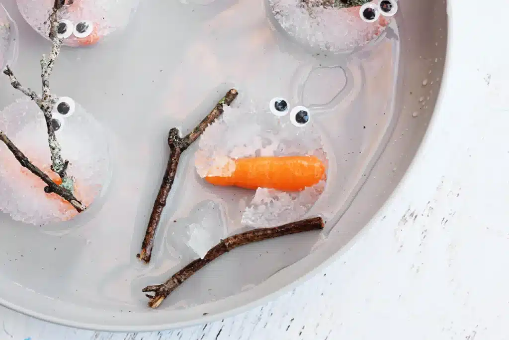 Melting Snowman Sensory Activity - Cultivating Brilliant Minds snowman pieces frozen in ice melting on a plate