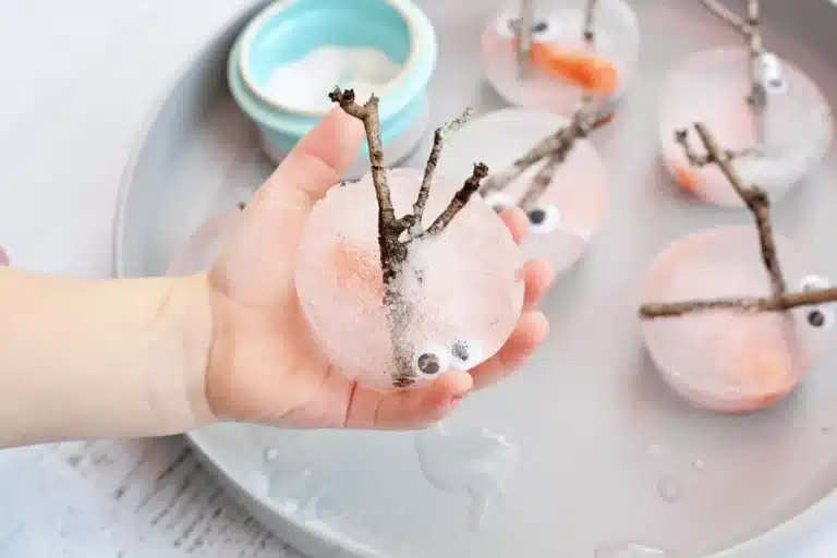 a kid holding snowman pieces frozen in ice