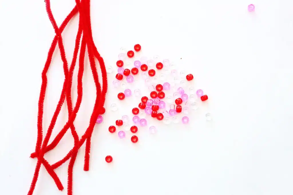 Pipe Cleaner Heart Lacing Fine Motor Activity - Cultivating Brilliant Minds pipe cleaners and red, white, and pink pony beads