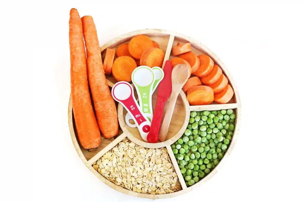 Reindeer Bait Sensory Bin - Cultivating Brilliant Minds carrots, tolled oats, peas, and measuring spoons