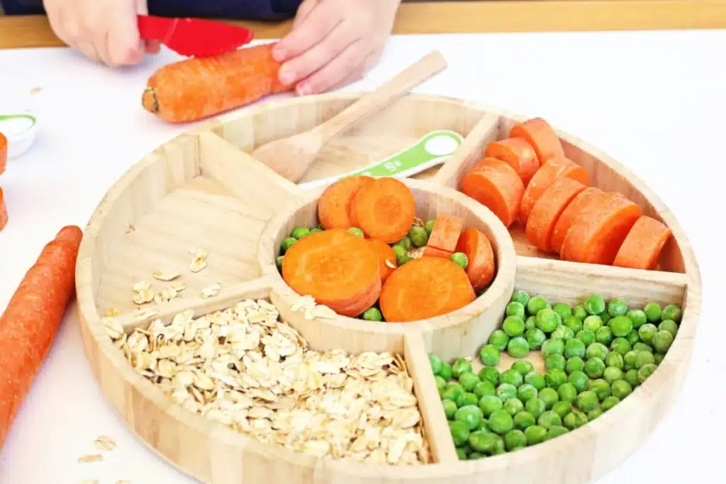 Reindeer Bait Sensory Bin - Cultivating Brilliant Minds a reindeer sensory bin filled with rolled oats, sliced carrots, and peas